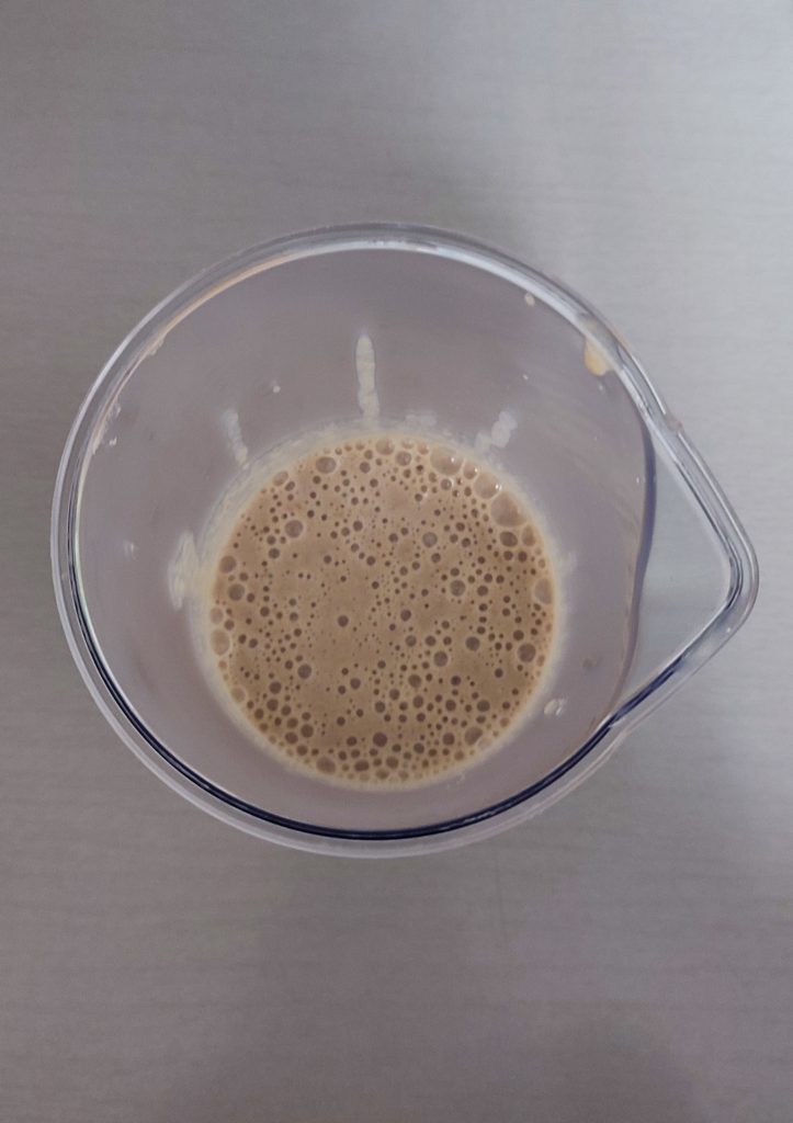 Vaso de batidora visto desde arriba con la poción lunar ya batida y con burbujas en la superficie.